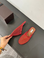 ALAIA FLAT MULES IN CHERRY RED MESH FISHNET